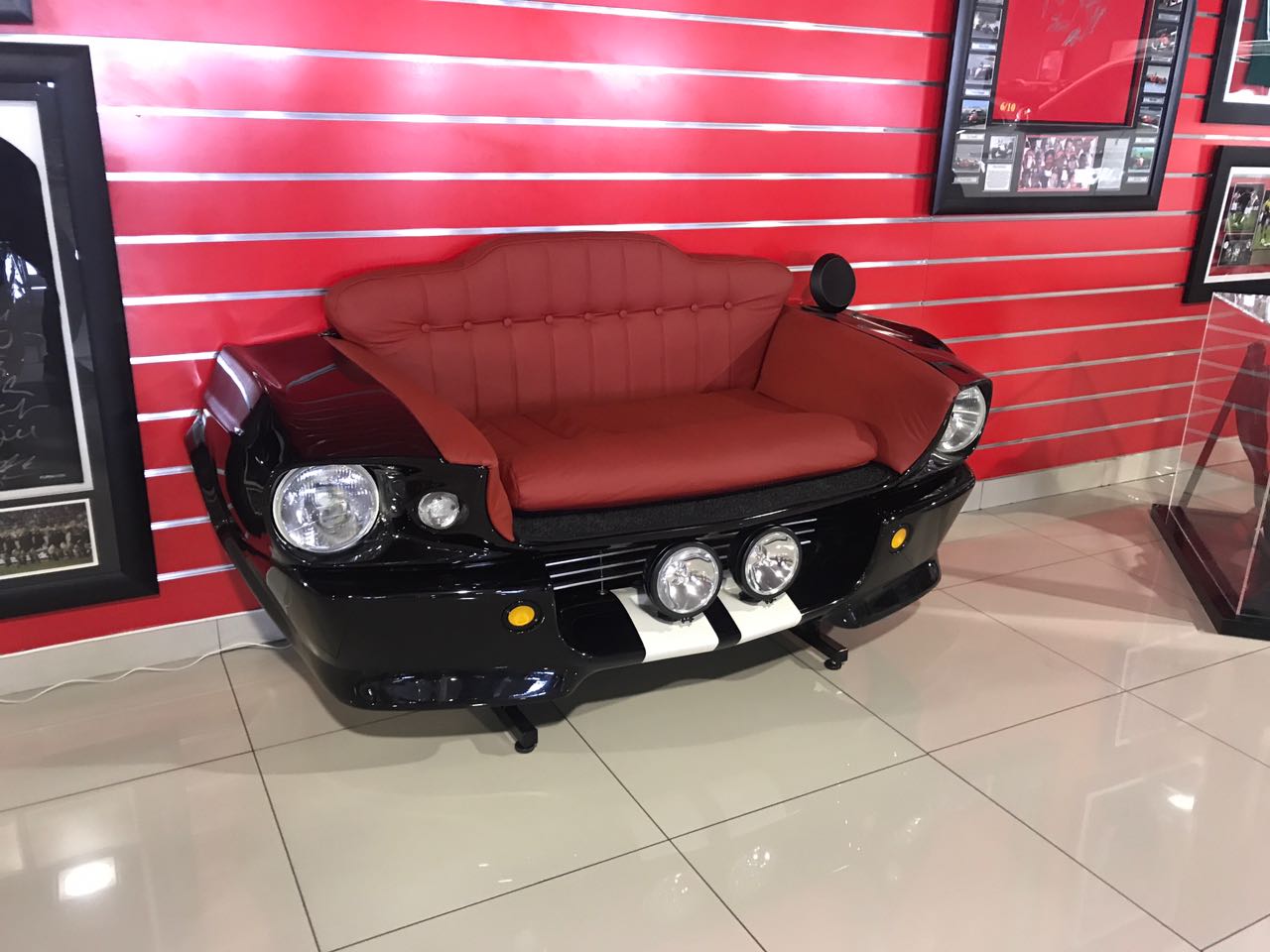 Black and red car-front couch installed in a showroom