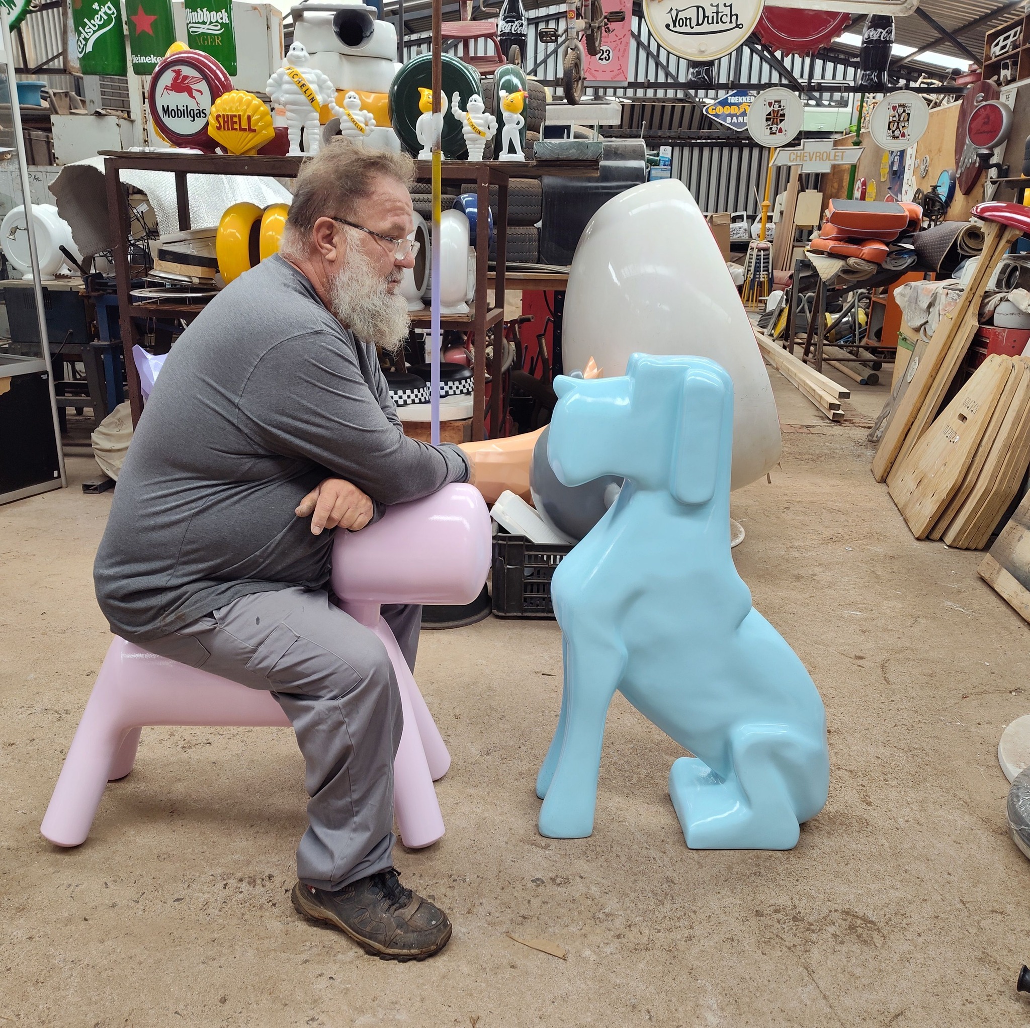 The maker sitting beside glossy fiberglass animal seats