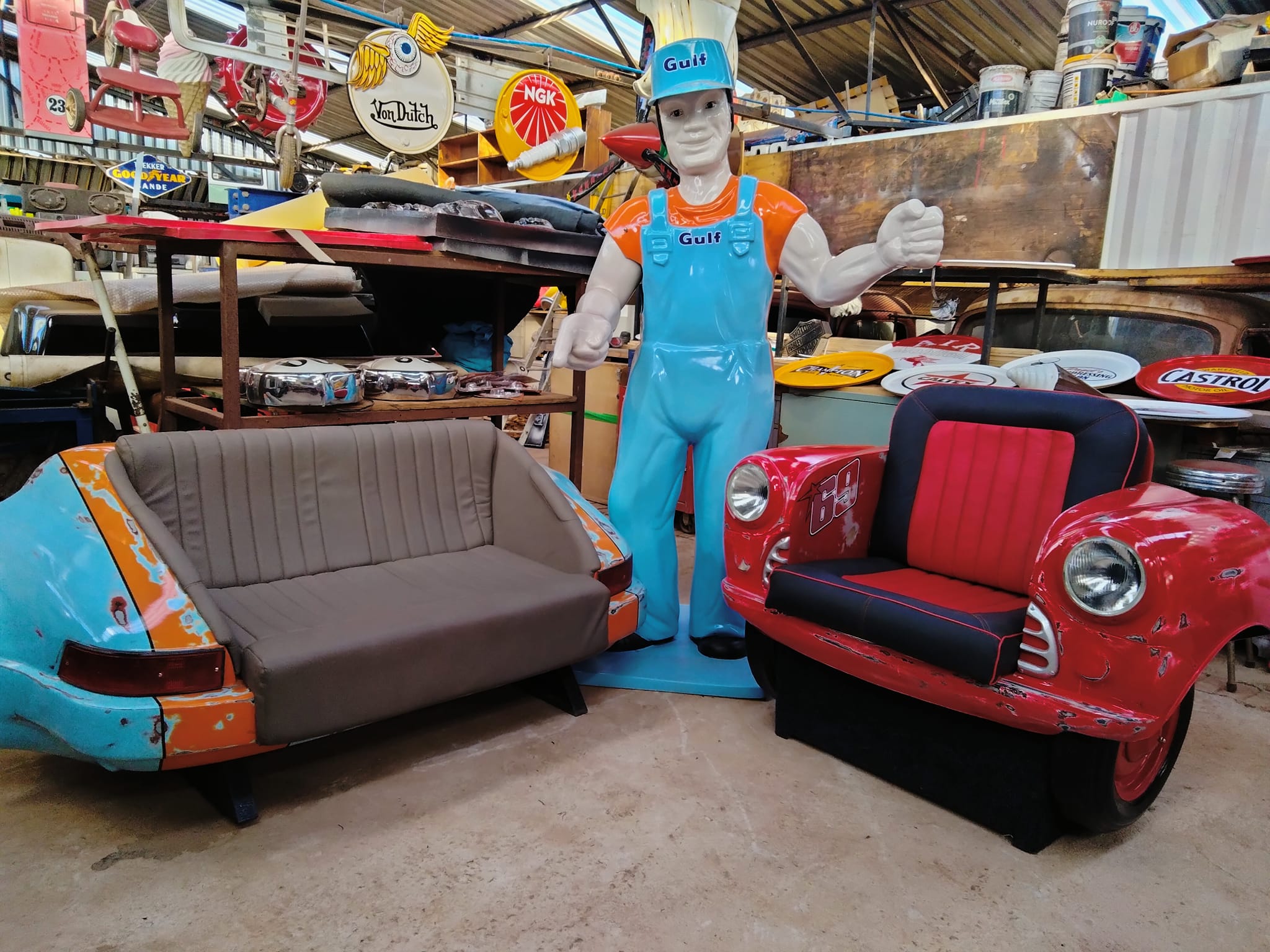 Custom fiberglass car couches and retro signs displayed in the workshop